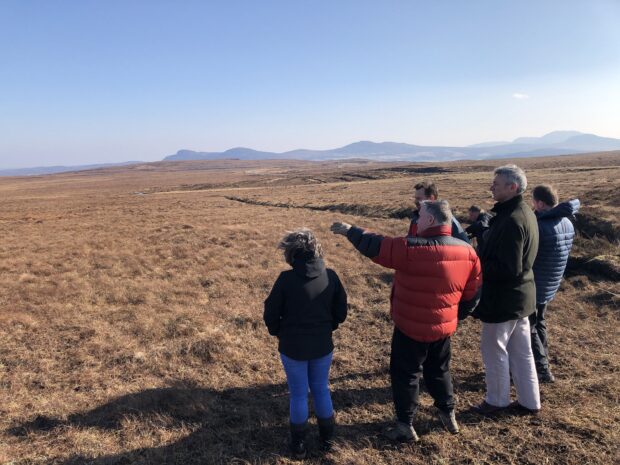 A group of people including the CEO and Deputy CEO of the UK Space Agency in a field in Scotland, the future site of Space Hub Sutherland