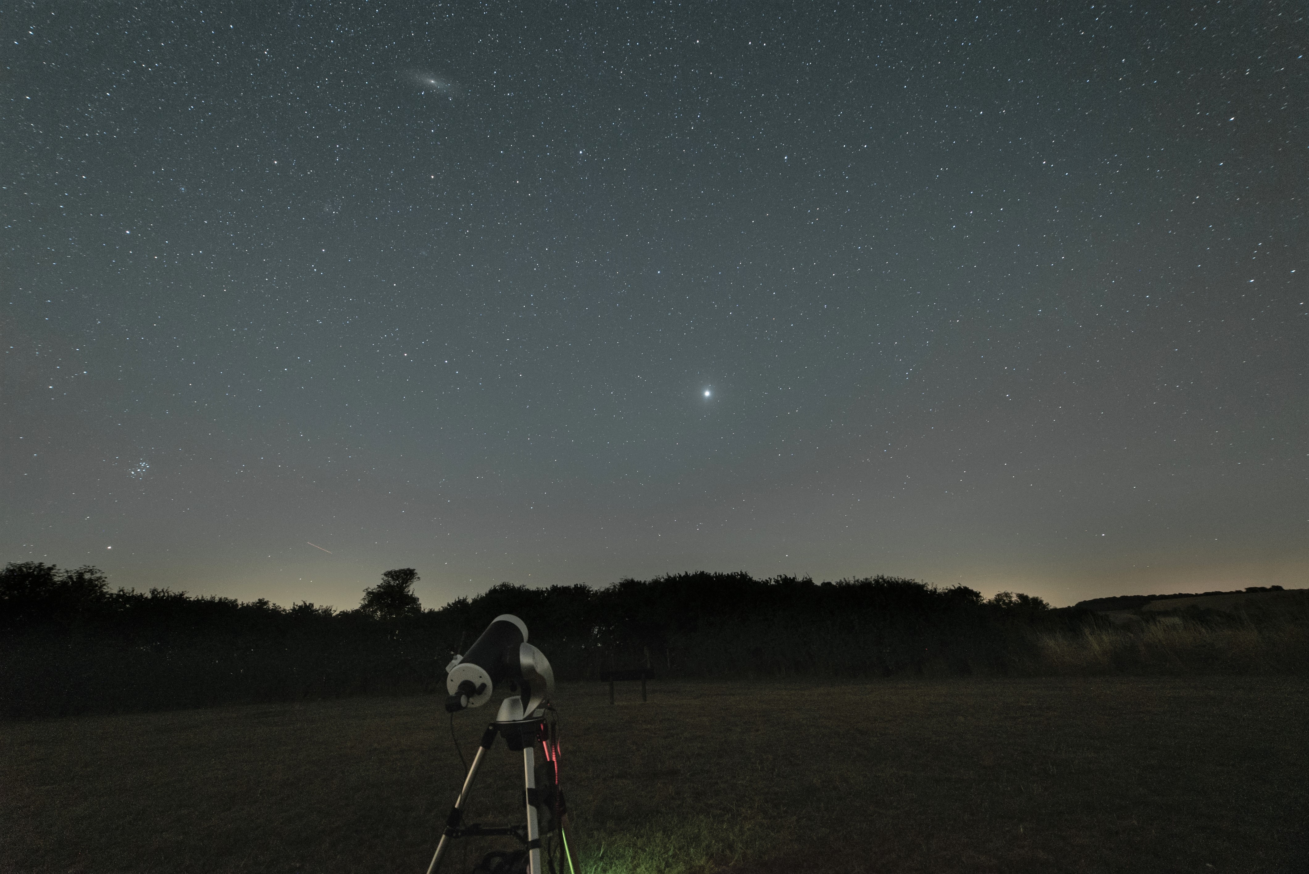 A telescope pointing at a bright object in the night sky.